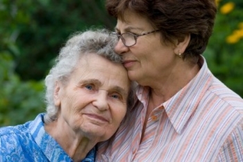 Woman caregiving for elderly parent.