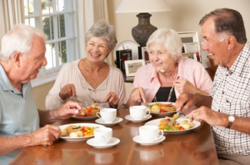 Senior couples eating together at retirement community.